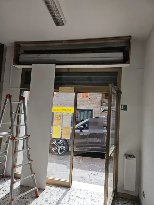 Riparazione di una serranda di un negozio a Modena con rullo smontato