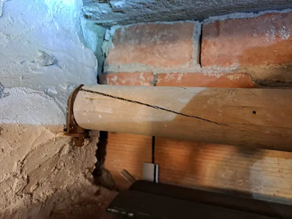 Vecchio rullo di legno crepato nel cassonetto di una tapparella a Modena